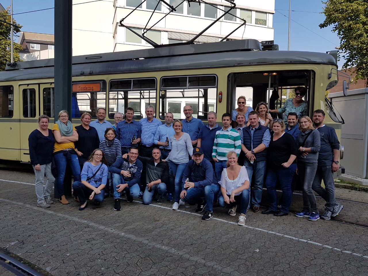 Kompanie vor Oldtimer-Straßenbahn